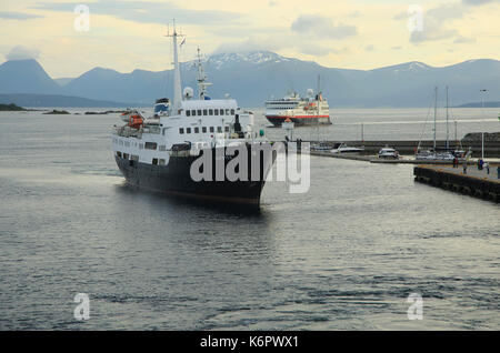 Two Hurtigruten ferry ships arriving at Molde, Norway the Lofoten is the oldest ship in the fleet Stock Photo