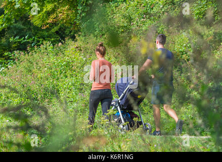Couple with a child in a pushchair having a countryside walk in Autumn in the UK. Stock Photo
