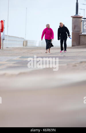 North Wales, 13th September 2017.  UK Weather. The first named storm of season that brought 75mph gales to a central belt of the UK and North Wales now passing over North East of the UK. The Amber Warning for wind and rain is now reduce to yellow warning over North Wales as these people discovered along the promenade in Rhyl this morning, Denbighshire, Wales © DGDImages/Alamy Live News Stock Photo
