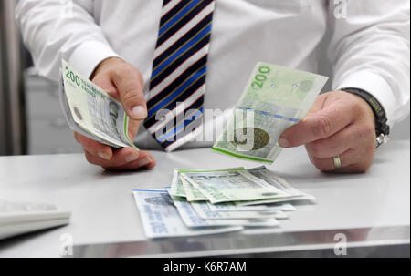 Munich, Germany. 13th Sep, 2017. ILLUSTRATION - An employsee counts Danish Krone at an exchange office in Munich, Germany, 13 September 2017. President of the European Commission Juncker wants to introduce the Euro in the entire European Union. Photo: Tobias Hase/dpa/Alamy Live News Stock Photo