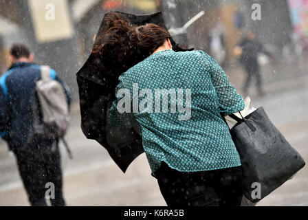 Berlin, Germany. 13th Sep, 2017. A young woman walks with her umbrella raised against the wind in Berlin, Germany, 13 September 2017. Photo: Britta Pedersen/dpa-Zentralbild/dpa/Alamy Live News Stock Photo