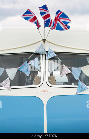 Vintage caravan window detail with floral bunting at a vintage retro festival. UK Stock Photo