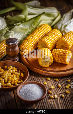 Homemade golden corn cob with salt on table Stock Photo