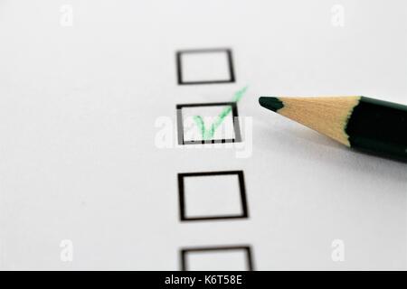 An concept Image of a green pencil and a questionnaire Stock Photo