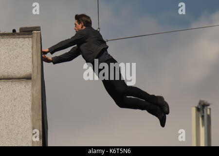 Tom Cruise leaps from the roof of one building to another while filming the next film in the 'Mission: Impossible' series; Cruise appeared to injure himself in the stunt and required medical treatment.  The 55-year-old action man was injured during a big building-jump stunt on the set of the blockbuster in London on Sunday (13Aug17) - which was caught on camera. Cruise appeared to miss his mark while jumping from construction rigging onto a nearby building, and slammed gainst the wall. Clambering up the wall and getting to his feet, the movie star limped for a few yards and then collapsed in f Stock Photo