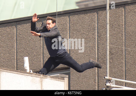 Tom Cruise leaps from the roof of one building to another while filming the next film in the 'Mission: Impossible' series; Cruise appeared to injure himself in the stunt and required medical treatment.  The 55-year-old action man was injured during a big building-jump stunt on the set of the blockbuster in London on Sunday (13Aug17) - which was caught on camera. Cruise appeared to miss his mark while jumping from construction rigging onto a nearby building, and slammed gainst the wall. Clambering up the wall and getting to his feet, the movie star limped for a few yards and then collapsed in f Stock Photo