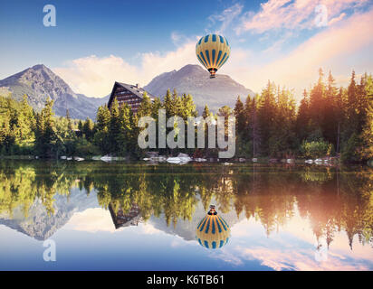 The sunrise over a lake in the park High Tatras. Collage mountains and balloon. Shtrbske Pleso, Slovakia, Europe Stock Photo