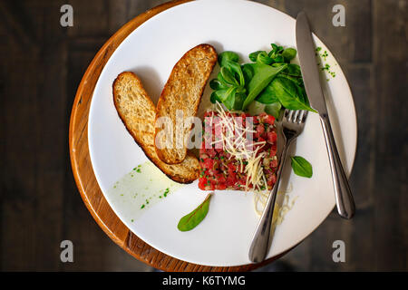 Beef Carpaccio and salad on dark background Stock Photo
