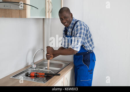 Man Using a Plunger to unstop his bathroom sink 4817267 Stock Photo at  Vecteezy