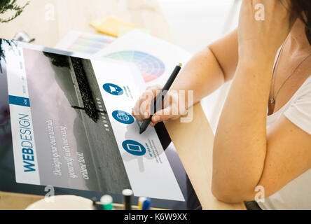 web designer working on a tablet. All screen graphics are made up. Stock Photo