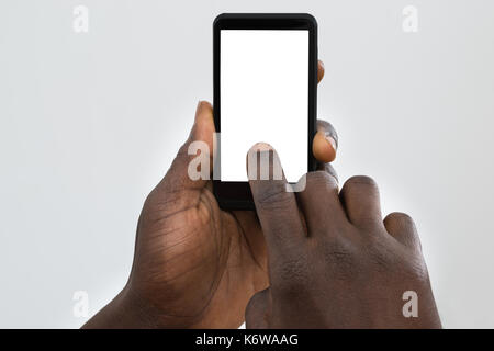 Close-up Of Person's Hand Using Cellphone With Blank Screen Stock Photo
