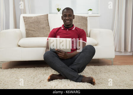Portrait Of Smiling Young African Using Digital Tablet Stock Photo