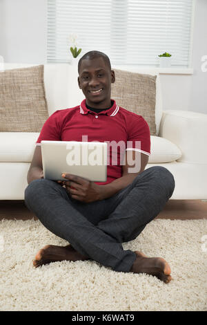 Portrait Of Smiling Young African Using Digital Tablet Stock Photo