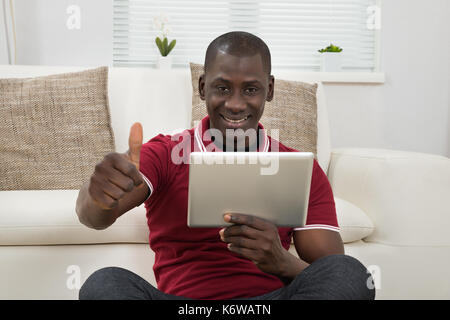 Portrait Of Smiling Young African Using Digital Tablet Stock Photo