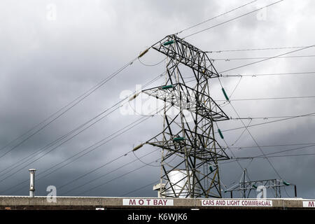An electricity pylon and the smoke stack of a power station seen in ...