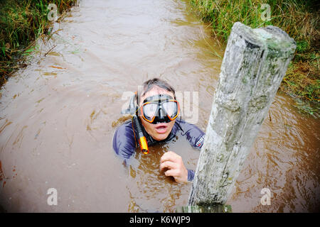 World Bog Snorkelling Championships Wales a cold exhausted competitor reaches the finish post Stock Photo