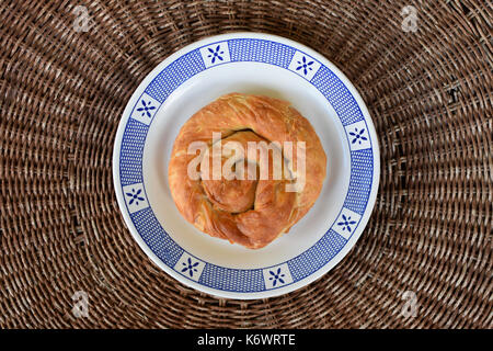 Greek food strifti pita spiral pie filled with feta cheese, leek or spinach. Mediterranean cuisine appetizer dish. Stock Photo