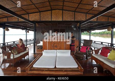 Laos, Champassak, lao woman, tourist and captain at the controls of the Vat Phou, on the wooden bridge of this boat cruise traditional sailing in the southern part of the Mekong Stock Photo