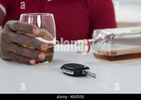 Close-up Of Man Holding Glass Of Whisky With Car Key On Table Stock Photo