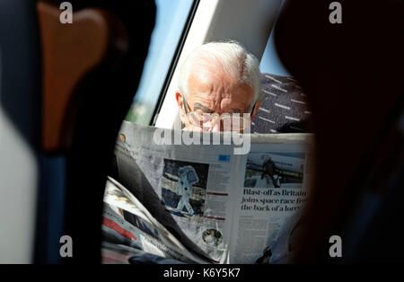 senior man reading newspaper on train Stock Photo