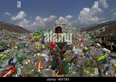 A boy works at a plastic recycling factory in Dhaka, Bangladesh on October 28, 2013. Stock Photo