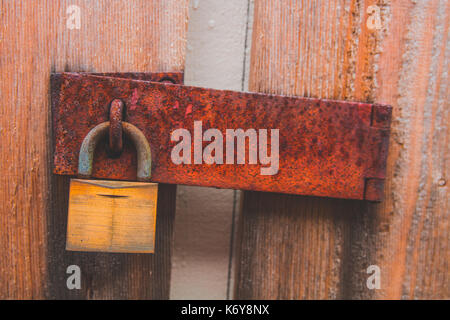 Rusty padlock on wooden door Stock Photo