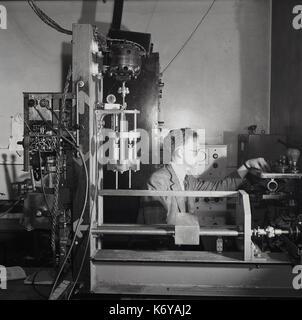 Early 1950s, post-ww2 Britain, picture shows a male chemistry researcher at Leeds University using specially designed apparatus or device for measuring fast reactions. Stock Photo