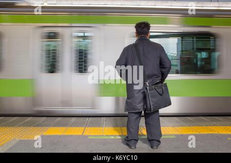 Japan, Tokyo, Shimbashi metro station, traveler in front of train Stock Photo