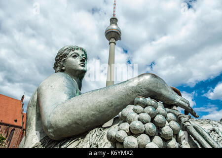 Germany A statue of the Neptunbrunnen (fontain of Neptune) with the tv tower Fernsehturm on the background, in Alexanderplatz, Berlin Stock Photo