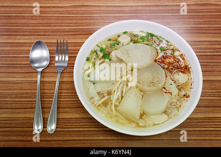 Pork soup with Thai noodles in a bowl on wood table. Stock Photo