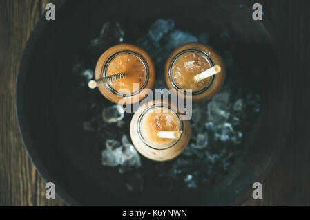 Cold Thai iced tea in bottles with milk, top view Stock Photo
