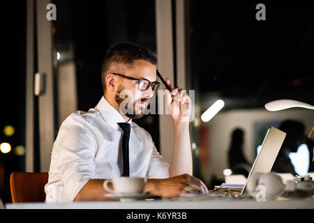 Businessman in the office at night working late. Stock Photo