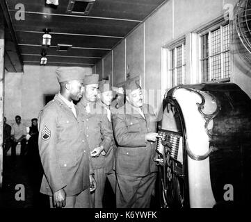 MILLS BROTHERS US vocal group. Group  member Private Harry Mills joins the US Army and checks the groups recordings on the reception centre jukebox. Photo: US Dept of Defence Stock Photo