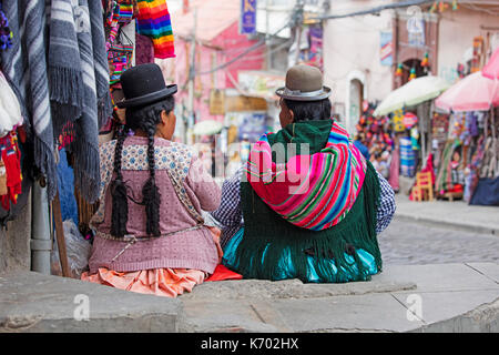 Two Bolivian women with long black hair braids in traditional cholita dress wearing bowler hats in the city La Paz, Bolivia Stock Photo