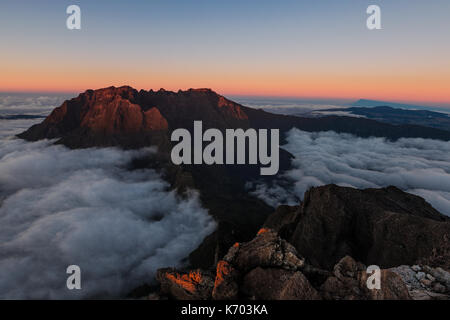 Sunset on a sea of clouds in volcano french island Stock Photo