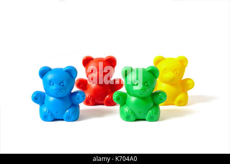 Small blue, red, yellow and green plastic toy bears isolated on white background arranged in two rows Stock Photo