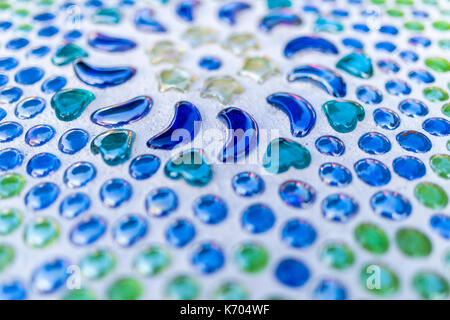 Blue and green beautiful decorative glass beads cemented in a table top Stock Photo