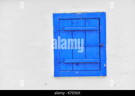Closed vintage blue window on white wall of old house in romania Stock Photo