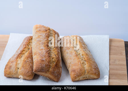 Ciabatta bread on cutting board, three loaves Stock Photo