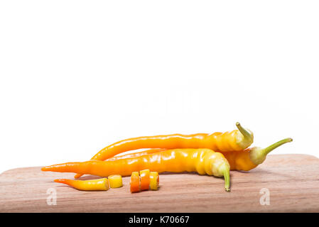 Whole chilli peppers and chilli pepper slices on cutting board with white background Stock Photo