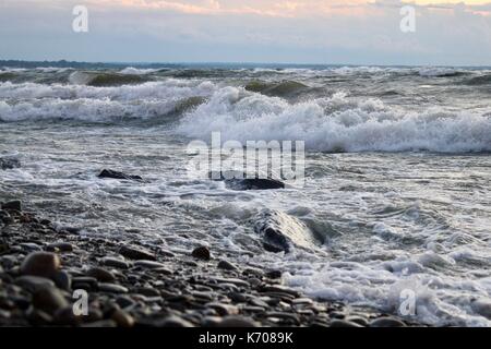 Waves crasing over rocks on the beach. Stock Photo