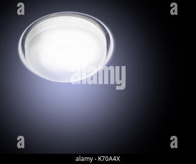 Ceiling Recessed LED lamp is lit close-up cold light on a black background. Stock Photo