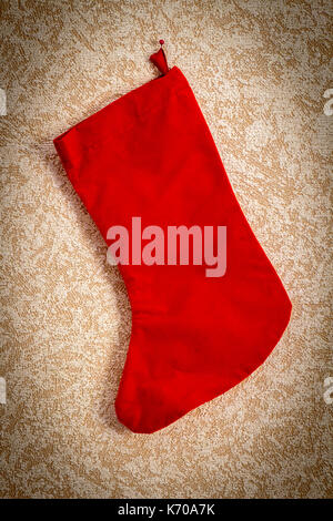 Red Christmas boot for gifts hanging on the wall close-up. Stock Photo