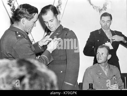 Brig. Gen. Claire Chennault (left) commander of the US Air Task Force, decorates Major Edward F. Rector with the Distinguished Flying Cross. Other officers decorated by Chennault were Major David Hill (seated) and Col. Robert L. Scott (standing). 1943.