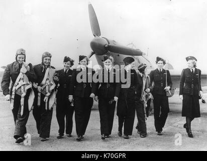AMERICAN WOMEN WHO FLY WARSHIPS TO THE MEN WHO FLY THEM AGAINST AXIS -- Women of the United Nations -- U.S. and British members of the A.T.A., ready to take up Hurricane fighter places for delivery to R.A.F. pilots. June 13, 1942. Stock Photo