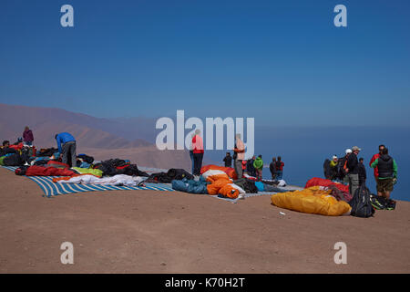 Group of people and paraglider waiting for suitable conditions to take off over the coastal city of Iquique on the northern coast of Chile. Stock Photo