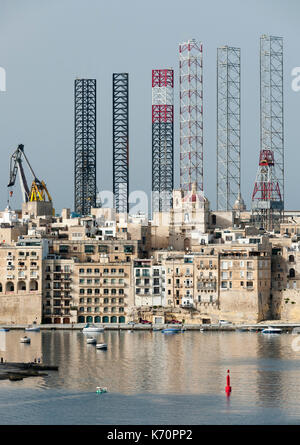 Jackup oil drilling rigs juxtaposed with the Senglea waterfront in Valletta, Malta. Stock Photo