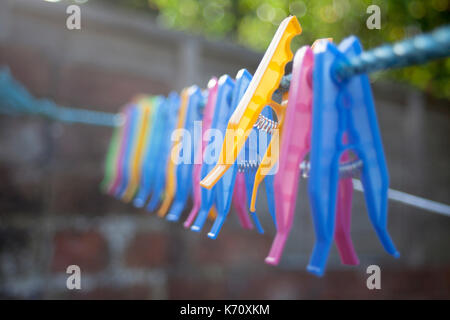 Plastic clothes pegs laying on the wire. Stock Photo