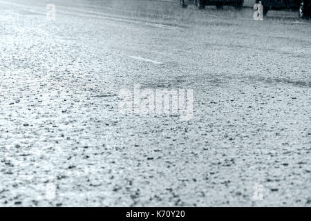 flooded asphalt road with raindrops during heavy rain Stock Photo