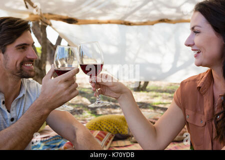 Happy young couple toasting wineglasses in tent Stock Photo